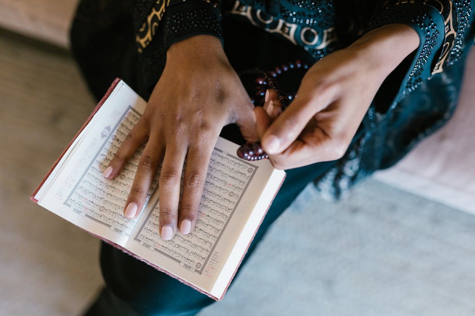 Foto sebuah mushaf Al-Quran tua dengan tulisan kaligrafi yang indah terbuka di atas meja kayu di dalam perpustakaan klasik yang tenang, dengan cahaya matahari pagi yang masuk melalui jendela masjid menyinari halaman-halamannya.
