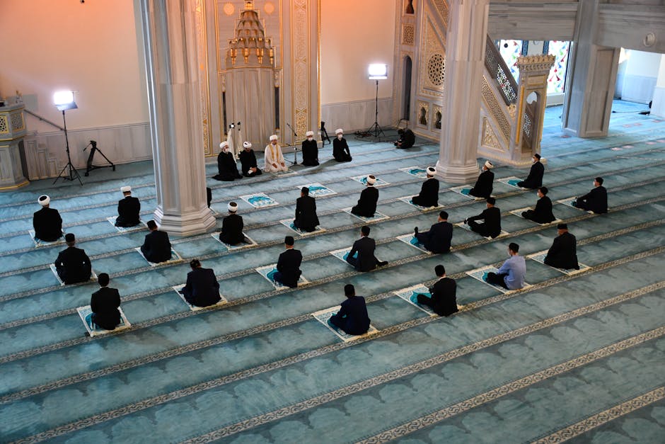 Foto sebuah mushaf Al-Quran yang terbuka di atas meja kayu di dalam sebuah perpustakaan klasik dengan pencahayaan hangat yang masuk dari jendela masjid, menciptakan suasana tenang dan penuh ilmu.