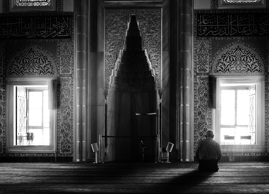 Foto sebuah naskah kuno kitab hadits yang terbuka di atas meja kayu jati di dalam perpustakaan klasik dengan cahaya matahari pagi yang masuk melalui celah jendela masjid, menciptakan suasana yang tenang dan penuh wibawa keilmuan.