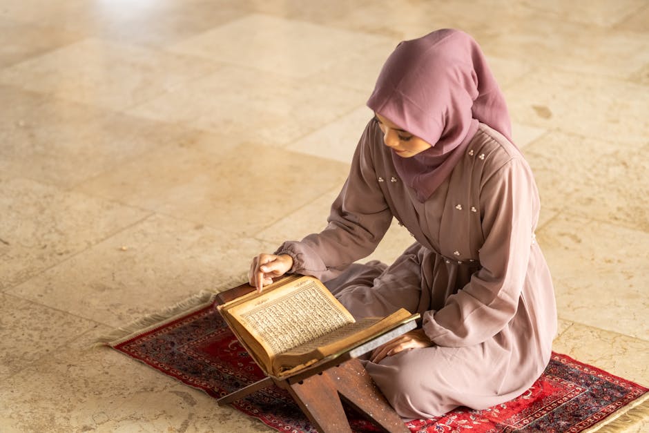 Foto sebuah mushaf Al-Quran terbuka di atas rehal kayu dengan latar belakang interior masjid yang diterangi cahaya matahari sore yang lembut, menciptakan suasana tenang dan kontemplatif.