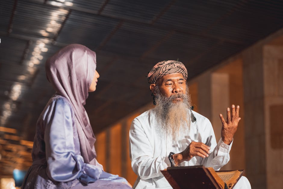 Foto sebuah mushaf Al-Quran kuno dengan tulisan kaligrafi yang indah terbuka di atas meja kayu di dalam sebuah perpustakaan klasik yang diterangi cahaya temaram dari jendela masjid, menciptakan suasana ketenangan intelektual dan spiritual yang mendalam.