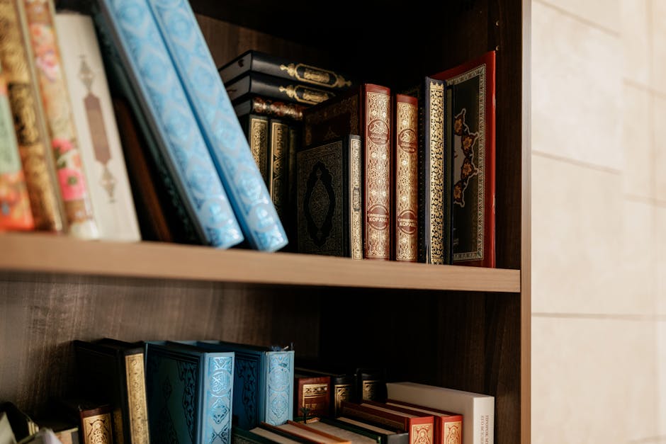 Foto sebuah mushaf Al-Quran tua yang terbuka di atas meja kayu di dalam perpustakaan klasik