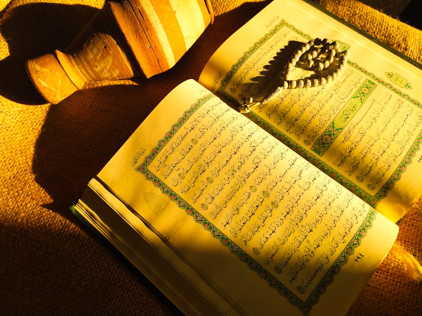 Foto sebuah mushaf Al-Quran terbuka dengan pencahayaan hangat di dalam sebuah perpustakaan klasik Islam, dikelilingi oleh tumpukan kitab-kitab turats yang memberikan kesan keilmuan yang dalam dan tenang.