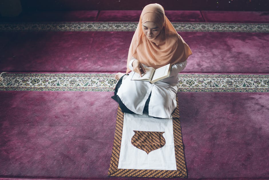 Foto sebuah mushaf Al-Quran tua yang terbuka di atas meja kayu di dalam perpustakaan masjid yang tenang, dengan cahaya matahari pagi yang masuk melalui jendela menciptakan suasana spiritual yang mendalam.