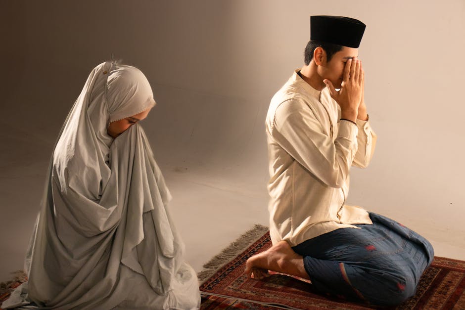 Foto sebuah naskah kuno kitab hadits dengan tinta emas yang terbuka di atas meja kayu berukir, di sampingnya terdapat segelas air dan kurma dengan latar belakang cahaya matahari terbenam yang masuk melalui jendela masjid yang artistik.