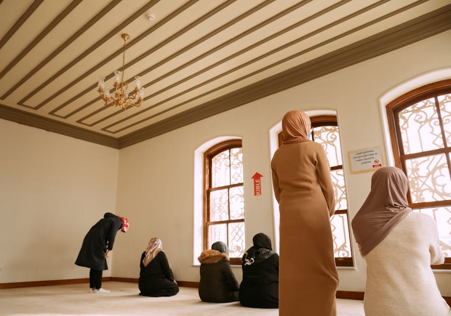 Suasana keberangkatan bantuan kemanusiaan yang melibatkan relawan Muslim dengan latar belakang bendera-bendera negara Islam dan tumpukan logistik bantuan medis.