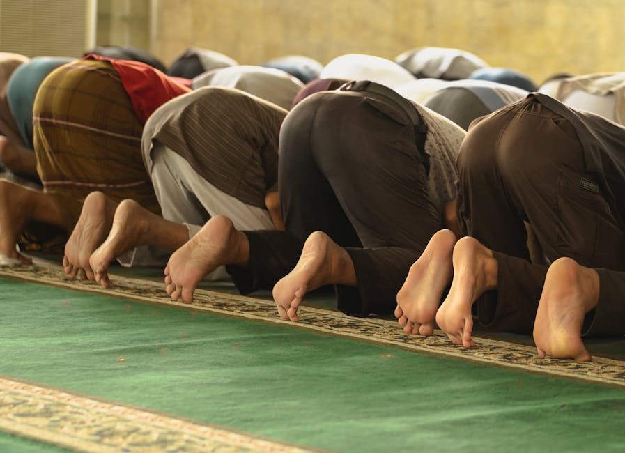 Foto naskah klasik kitab kuning bertuliskan kaligrafi Arab yang diletakkan di atas meja kayu tua dengan latar belakang rak buku perpustakaan Islam yang tenang dan berwibawa.