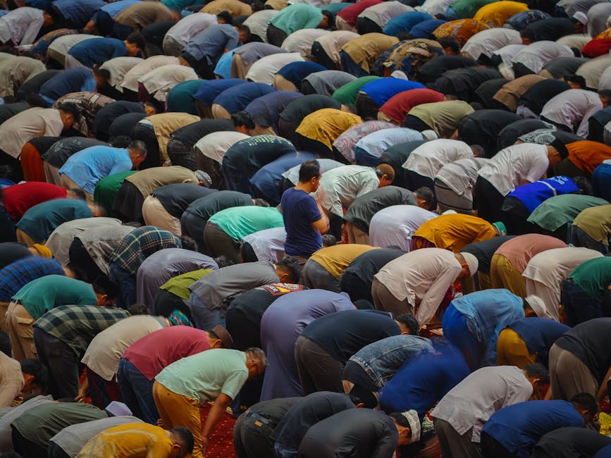 Foto sebuah naskah klasik kitab kuning yang terbuka di atas meja kayu dengan pencahayaan hangat, di sampingnya terdapat pena bulu dan tinta, menciptakan suasana perpustakaan ulama yang penuh dengan khazanah keilmuan Islam.