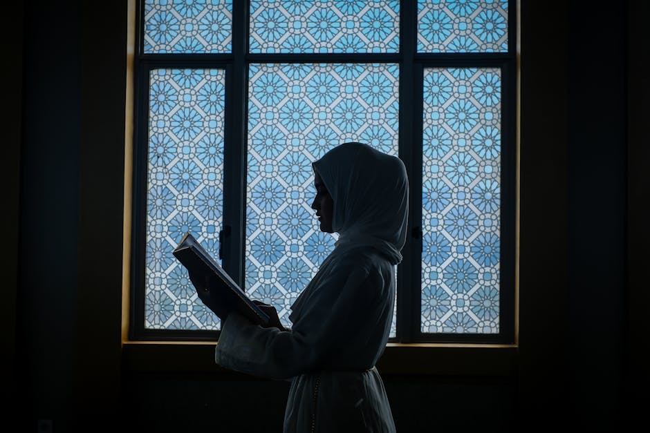 Foto sebuah naskah klasik kitab kuning tentang ilmu kalam yang terbuka di atas meja kayu dengan pencahayaan hangat, dikelilingi oleh tumpukan buku-buku referensi agama di sebuah perpustakaan Islam yang tenang.