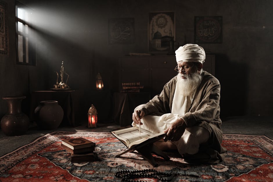 Foto sebuah naskah klasik kitab kuning gundul yang terbuka di atas meja kayu dengan pencahayaan hangat, dikelilingi oleh rak buku perpustakaan Islam yang penuh dengan literatur teologi dan tafsir.