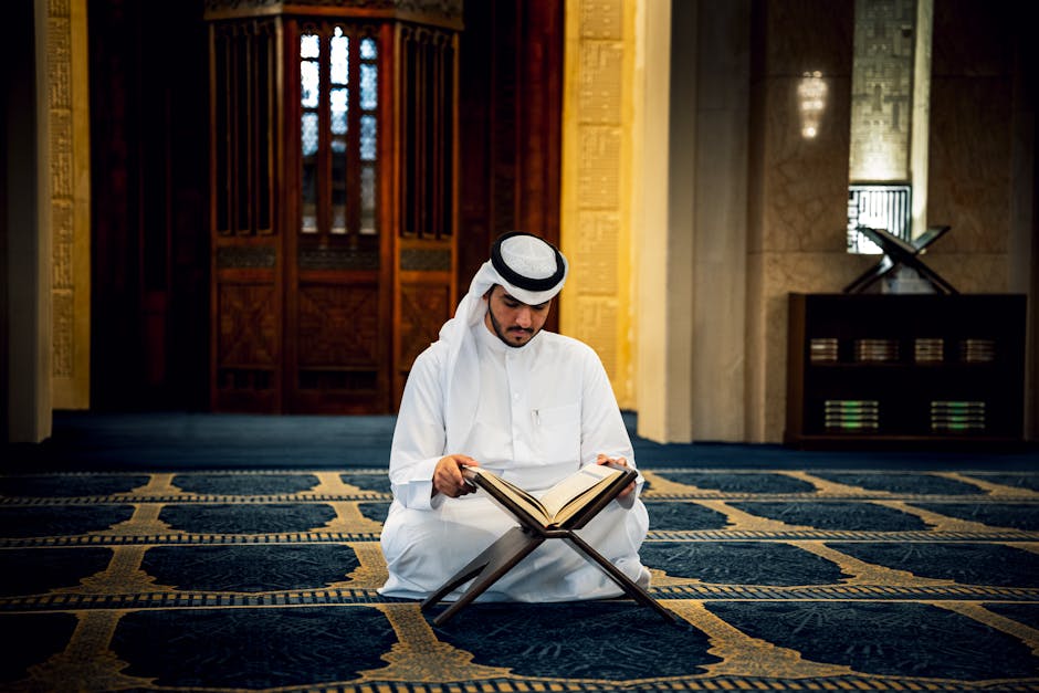 Foto sebuah naskah kitab kuning klasik yang terbuka di atas meja kayu dengan latar belakang perpustakaan Islam yang dipenuhi deretan kitab-kitab tebal, menciptakan suasana keilmuan yang mendalam dan tenang.