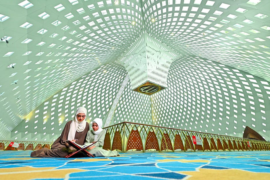 Foto sebuah naskah klasik kitab kuning yang terbuka di atas meja kayu tua dengan pencahayaan hangat, di sampingnya terletak tasbih dan latar belakang interior masjid yang memiliki arsitektur geometris islami yang tenang dan megah.