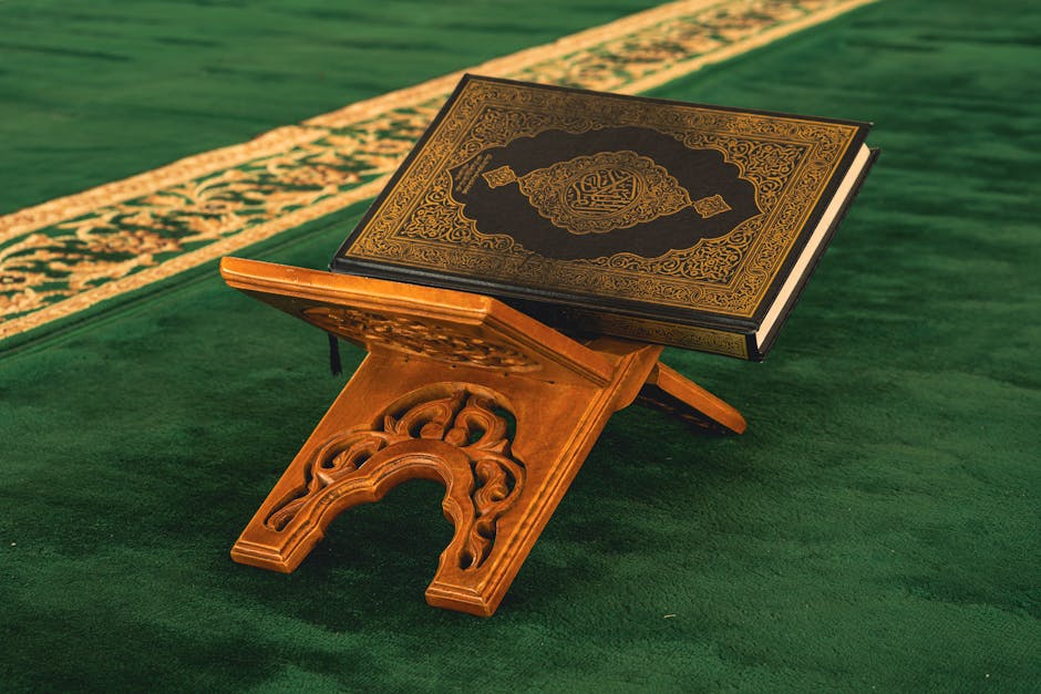 Foto sebuah mushaf Al-Quran yang terbuka di atas meja kayu di dalam perpustakaan masjid yang tenang dengan cahaya matahari pagi yang lembut masuk melalui jendela, menciptakan suasana khidmat dan penuh ilmu.