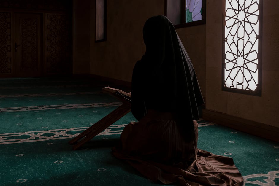 Foto sebuah mushaf Al-Quran tua yang terbuka di atas meja kayu di dalam perpustakaan masjid yang tenang dengan cahaya matahari pagi yang masuk melalui jendela, menciptakan suasana spiritual yang mendalam.