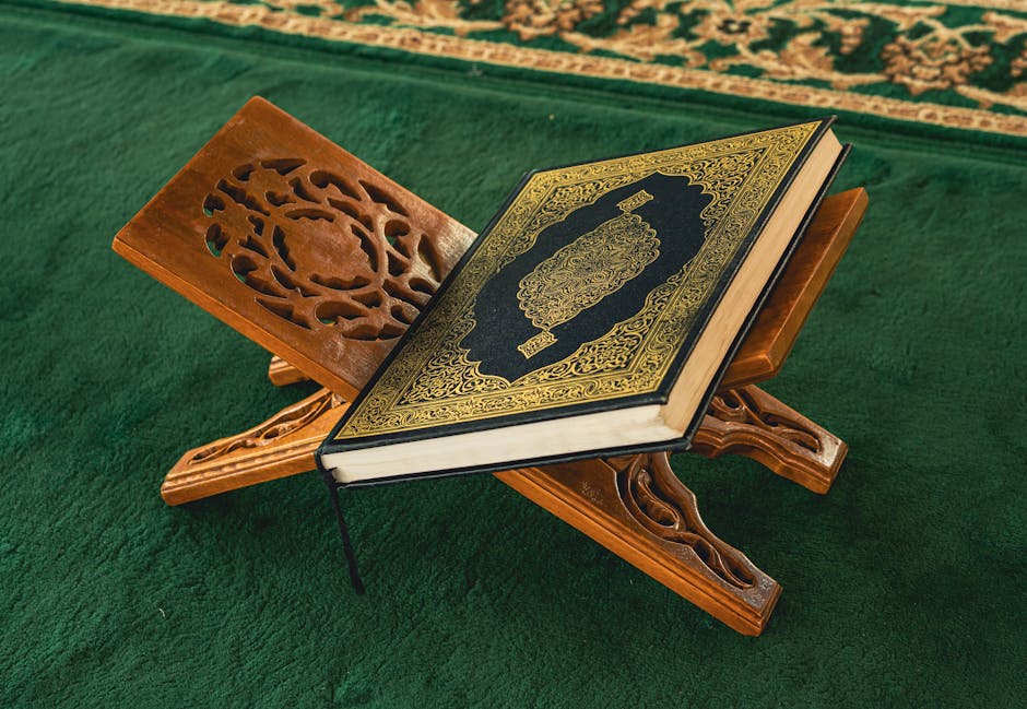 Foto sebuah mushaf Al-Quran tua yang terbuka dengan pencahayaan hangat di dalam sebuah perpustakaan klasik yang dipenuhi kitab-kitab kuning, melambangkan kedalaman ilmu dan tradisi intelektual Islam.