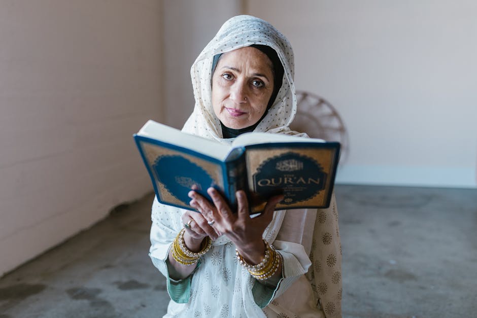 Foto sebuah mushaf Al-Quran yang terbuka di atas meja kayu di dalam perpustakaan klasik dengan cahaya matahari pagi yang masuk melalui jendela, menciptakan suasana tenang dan penuh ilmu.