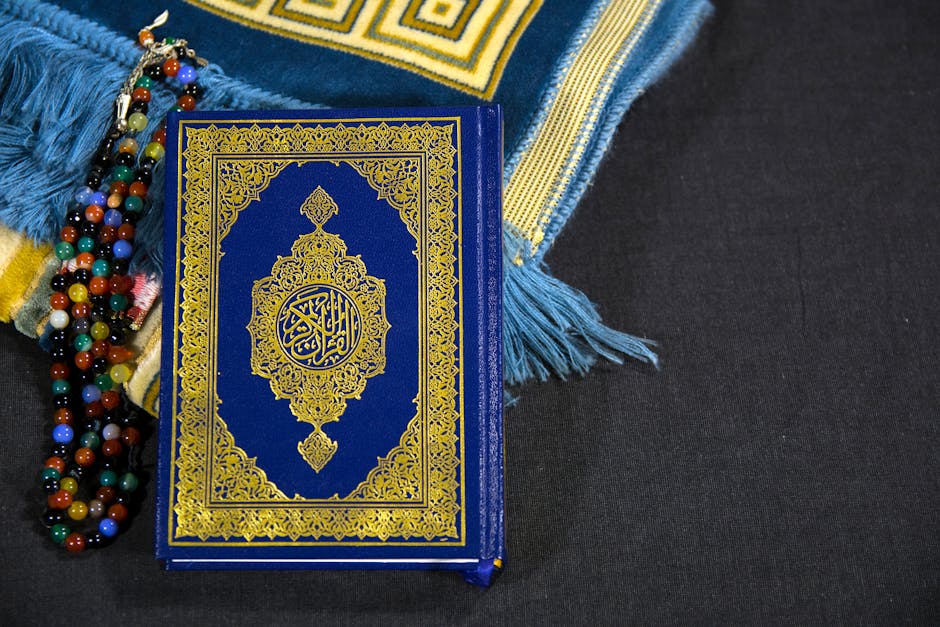 Foto sebuah mushaf Al-Quran yang terbuka di atas meja kayu di dalam perpustakaan klasik yang dipenuhi kitab-kitab kuning, dengan cahaya matahari pagi yang masuk melalui jendela masjid, menciptakan suasana tenang dan penuh ilmu.