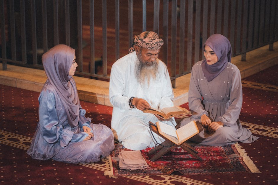 Foto sebuah mushaf Al-Quran terbuka dengan khat yang indah di atas meja kayu di dalam sebuah perpustakaan klasik yang tenang, dikelilingi oleh kitab-kitab turats yang melambangkan kedalaman ilmu pengetahuan Islam.