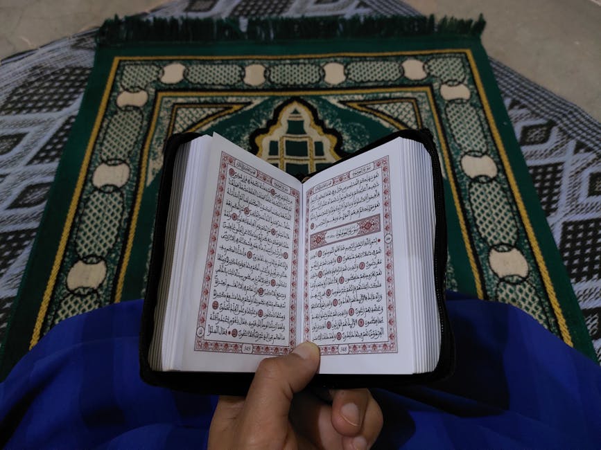 Foto sebuah mushaf Al-Quran terbuka dengan khat yang indah di atas meja kayu di dalam perpustakaan klasik yang dipenuhi kitab-kitab kuning, cahaya matahari pagi masuk melalui jendela masjid memberikan suasana tenang dan ilmiah.