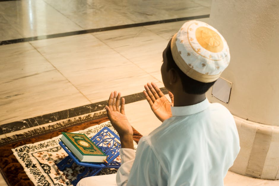 Foto sebuah mushaf Al-Quran terbuka dengan pencahayaan hangat di atas meja kayu perpustakaan klasik yang dipenuhi kitab-kitab turats, menciptakan suasana keilmuan yang tenang dan mendalam.