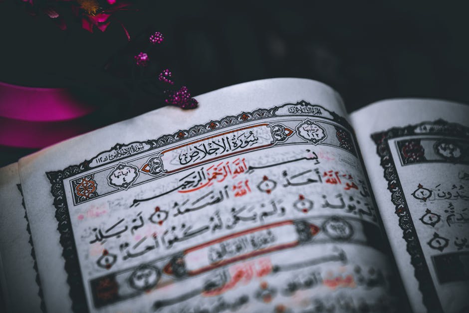 Foto sebuah mushaf Al-Quran yang terbuka dengan pencahayaan hangat di atas meja kayu di dalam perpustakaan klasik yang dipenuhi kitab-kitab kuning, melambangkan kedalaman ilmu dan tradisi intelektual Islam.