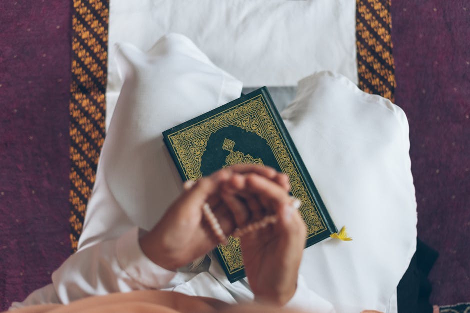 Foto sebuah mushaf Al-Quran yang terbuka dengan pencahayaan hangat di atas meja kayu perpustakaan klasik, dikelilingi oleh tumpukan kitab-kitab kuning karya ulama salaf, menciptakan suasana keilmuan yang mendalam dan tenang