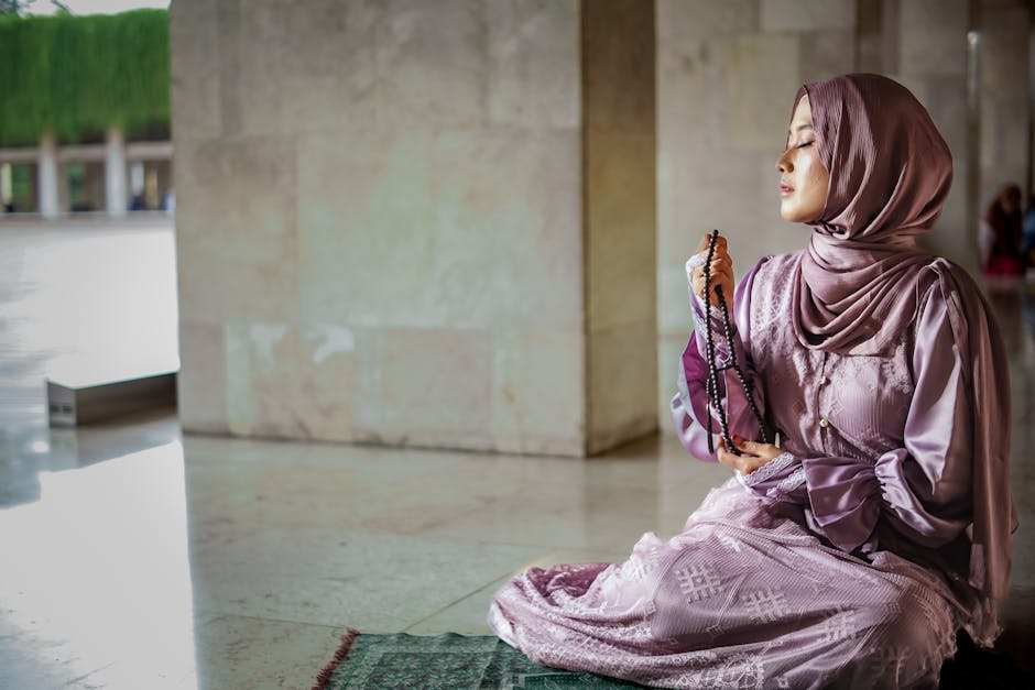 Ilustrasi seorang Muslimah sedang berdiskusi di depan meja kerja yang penuh dengan buku dan catatan, dengan latar belakang siluet kota modern dan masjid yang melambangkan keseimbangan duniawi dan ukhrawi.