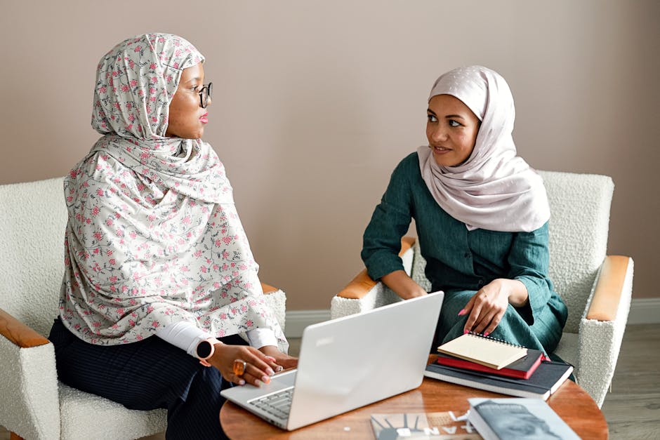 Ilustrasi seorang Muslimah yang sedang menulis di meja kerja dengan latar belakang perpustakaan dan jendela yang menampilkan pemandangan kota modern, melambangkan perpaduan antara ilmu pengetahuan tradisional dan kontribusi pada dunia modern.
