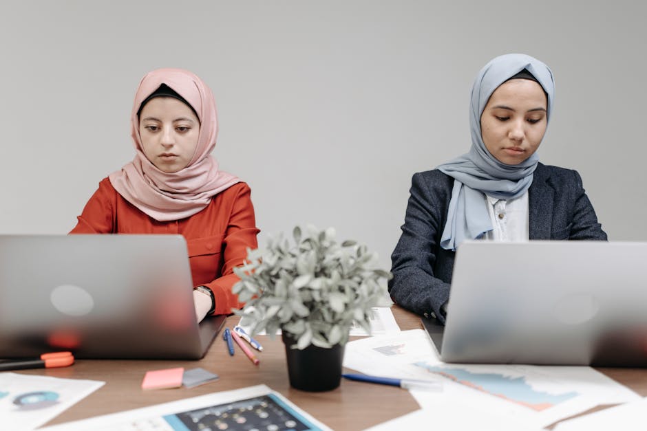 Ilustrasi seorang Muslimah yang sedang menulis di meja kerja dengan latar belakang perpustakaan klasik dan jendela yang menampilkan pemandangan kota modern, melambangkan perpaduan ilmu pengetahuan tradisional dan kemajuan zaman.