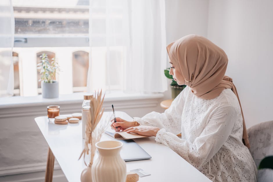 Ilustrasi seorang Muslimah yang sedang menulis di meja kerja dengan latar belakang rak buku yang penuh, melambangkan perpaduan antara intelektualitas dan nilai-nilai spiritual dalam membangun masyarakat.