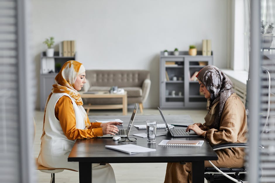 Ilustrasi seorang Muslimah yang sedang menulis di meja kerja dengan latar belakang perpustakaan dan jendela yang menampilkan siluet pemandangan kota modern, melambangkan perpaduan antara ilmu pengetahuan tradisional dan kemajuan zaman.