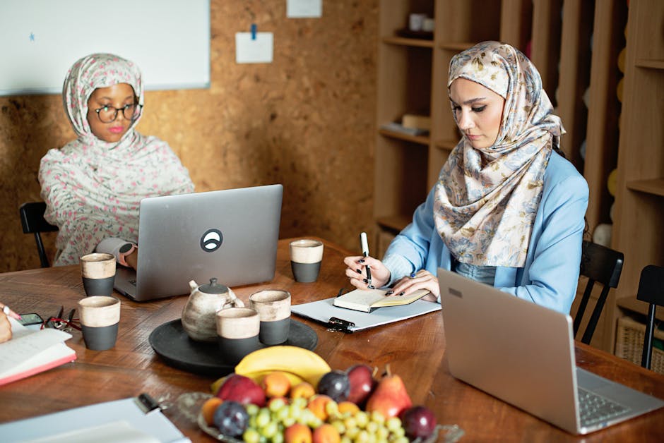 Ilustrasi seorang Muslimah terpelajar yang sedang menulis di meja kerja dengan latar belakang perpustakaan dan jendela yang menampilkan pemandangan kota modern, melambangkan perpaduan antara ilmu pengetahuan agama dan kontribusi pada kemajuan zaman.