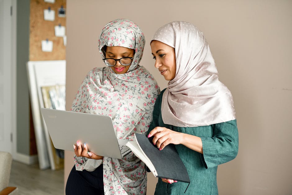 Ilustrasi seorang Muslimah profesional mengenakan hijab yang anggun sedang berdiskusi di ruang perpustakaan modern dengan buku-buku referensi ilmiah dan catatan rancangan pembangunan sosial di mejanya, memancarkan aura kecerdasan dan kesantunan.