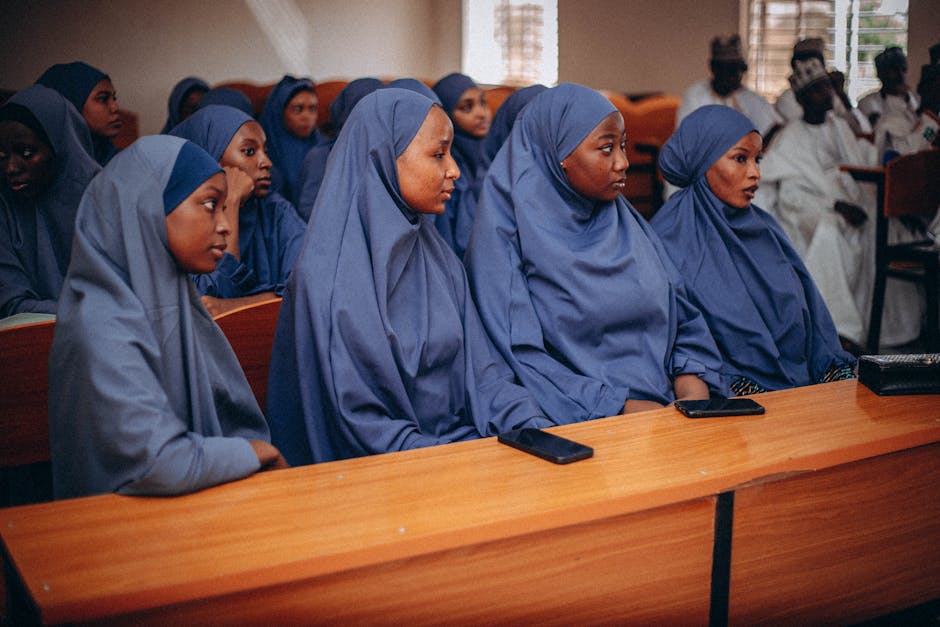 Deskripsi gambar: Seorang pemuda Muslim modern menggunakan hoodie dan headphone sedang duduk santai di taman kota sambil memegang buku catatan, suasana sore hari yang tenang dengan cahaya matahari terbenam yang lembut.