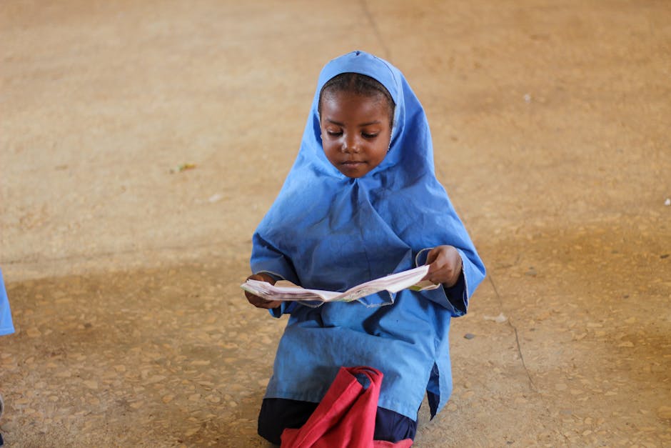 Seorang pemuda Muslim modern mengenakan hoodie dan tas punggung sedang duduk santai di sebuah kafe minimalis, ia tersenyum tenang sambil melihat pemandangan di luar jendela, dengan sebuah buku catatan dan secangkir kopi di depannya.