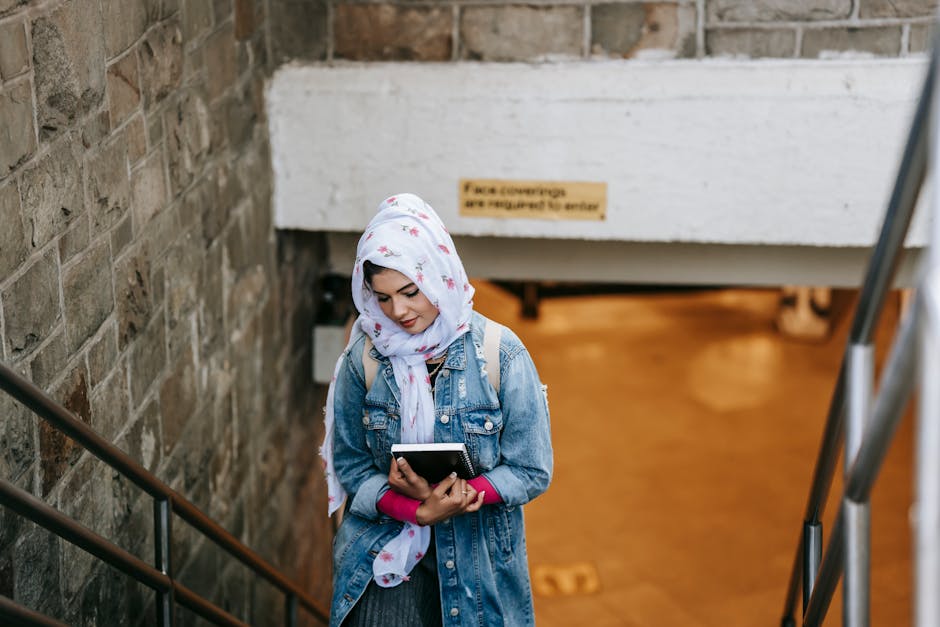 Seorang pemuda Muslim mengenakan hoodie modern sedang duduk santai di sebuah taman kota yang asri sambil memegang buku catatan, ekspresinya terlihat tenang dan damai menghadap pemandangan senja.