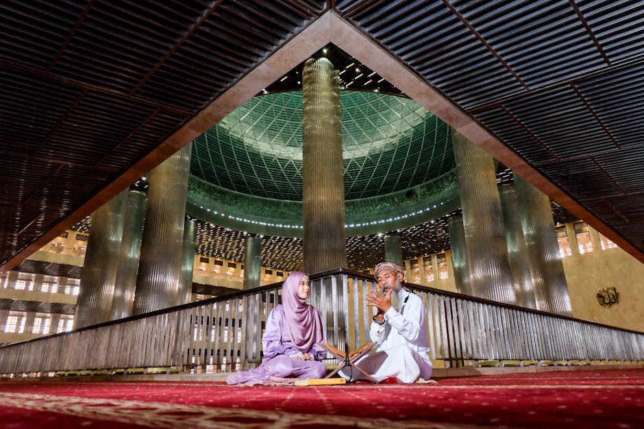 Foto estetik seorang pemuda Muslim sedang duduk santai di sebuah kafe modern dengan pencahayaan hangat, ia tampak tenang sambil memegang buku catatan dan ada segelas kopi di meja, mencerminkan suasana refleksi diri yang damai.
