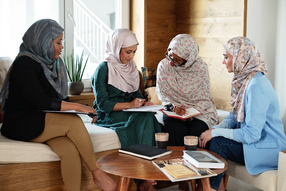 Foto estetik seorang pemuda Muslim sedang duduk santai di taman kota yang modern sambil memegang buku dan kopi, terlihat tenang dan damai dengan pemandangan gedung-gedung tinggi di latar belakang yang sedikit blur.