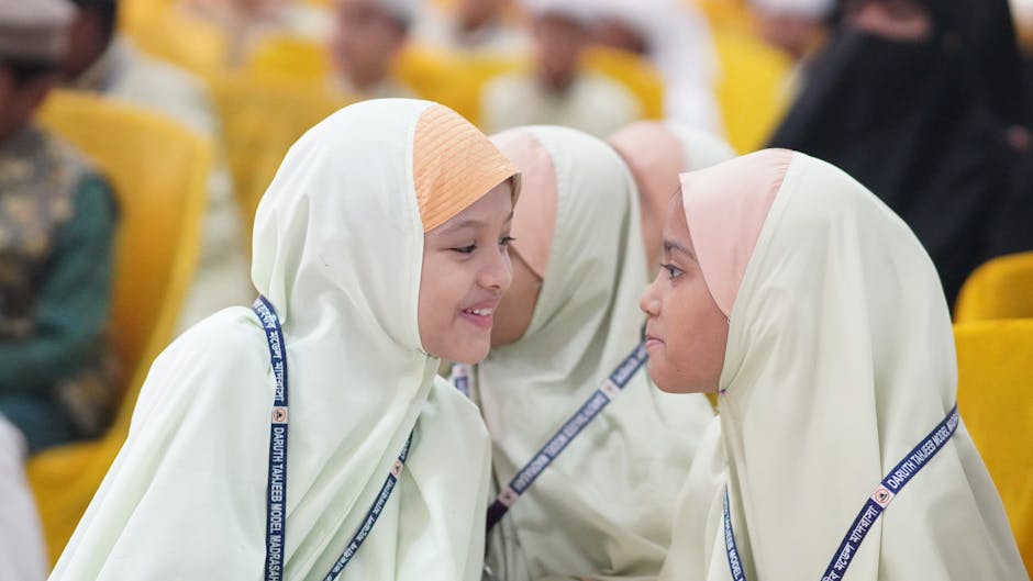 Foto estetik seorang pemuda Muslim yang sedang duduk santai di sebuah kafe modern dengan laptop dan buku catatan, sambil memegang secangkir kopi dan tersenyum tenang menatap jendela.