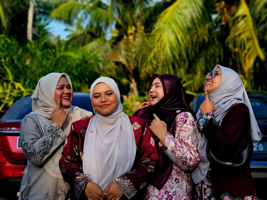 Seorang pemuda Muslim modern sedang duduk santai di sudut kafe estetik sambil memegang secangkir kopi hangat dan membaca Al-Qur'an digital dari smartphone-nya dengan ekspresi wajah yang tenang dan damai.