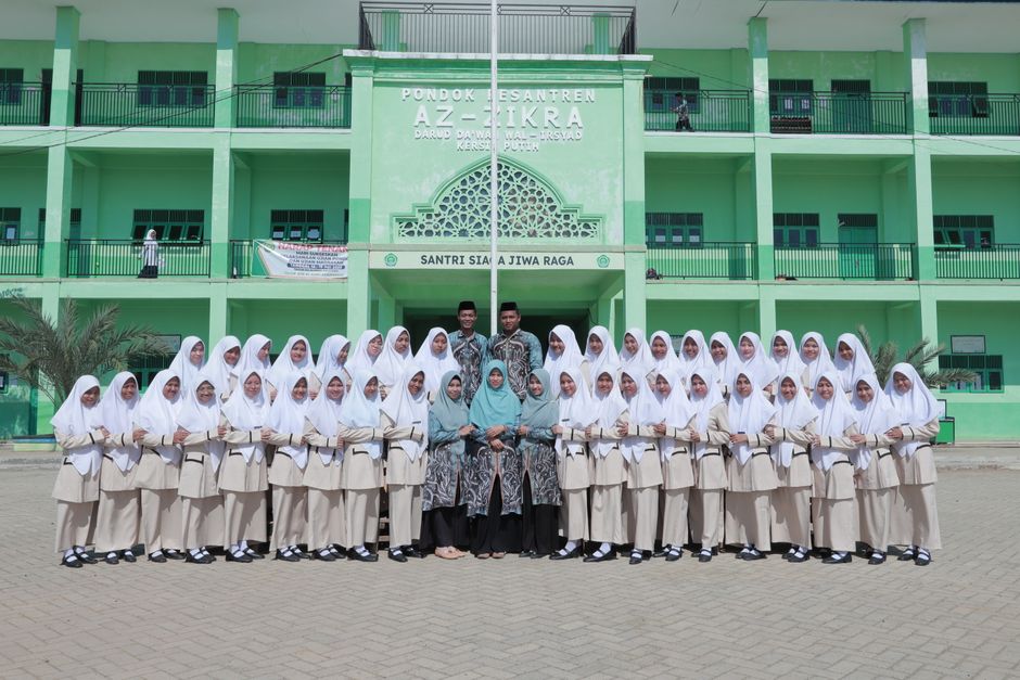 Tiga orang anak muda Muslim, dua perempuan berhijab kasual dan satu laki-laki, sedang duduk santai di area outdoor sebuah kafe modern estetik sambil berdiskusi hangat dengan laptop dan kopi di meja, memancarkan aura positif dan produktif.