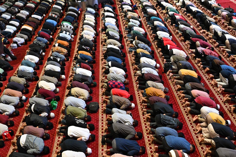 Foto naskah kuno kitab fiqih klasik dengan tulisan tangan Arab yang indah, diletakkan di atas meja kayu tua di dalam perpustakaan masjid yang tenang dengan pencahayaan alami yang lembut.