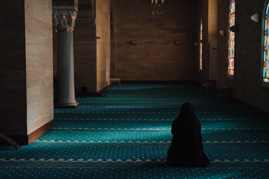 Foto naskah kuno kitab fiqih klasik dengan tulisan tangan Arab yang indah, diletakkan di atas meja kayu dengan pencahayaan hangat di dalam sebuah perpustakaan Islam tradisional yang tenang.