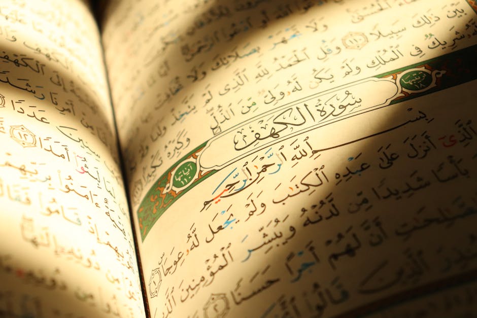 Foto sebuah mushaf Al-Quran terbuka yang diletakkan di atas rehal kayu di dalam sebuah masjid dengan pencahayaan alami yang lembut, dikelilingi oleh rak buku-buku kitab kuning klasik yang memberikan kesan keilmuan yang dalam dan tenang.