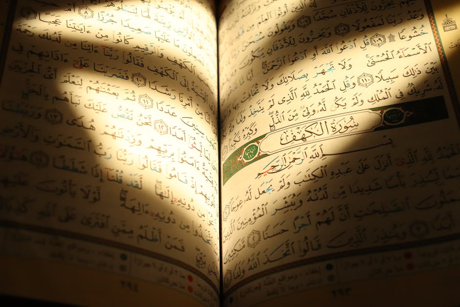 Foto sebuah mushaf Al-Quran yang terbuka di atas meja kayu di dalam perpustakaan klasik dengan pencahayaan hangat, dikelilingi oleh kitab-kitab turats kuno yang melambangkan kedalaman ilmu pengetahuan Islam.