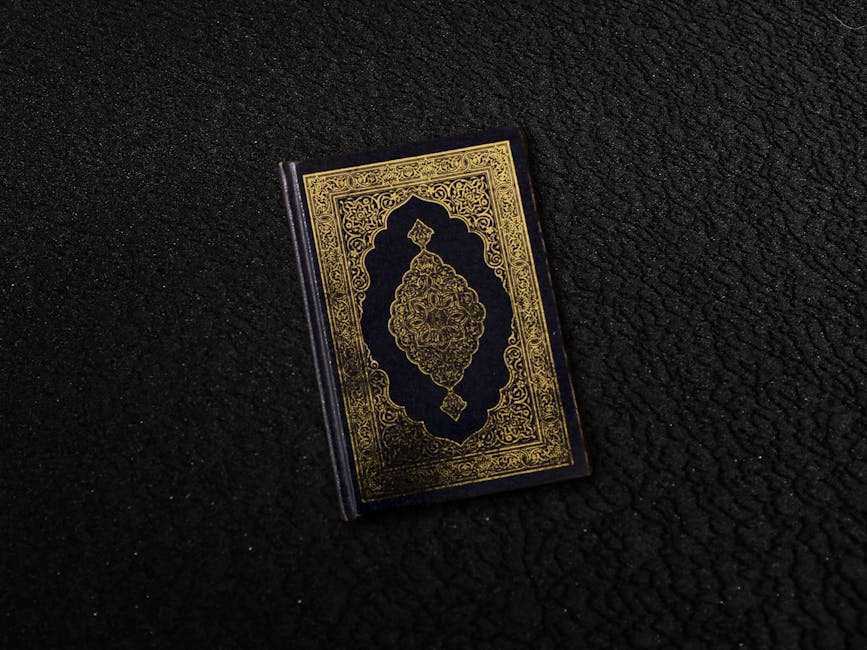 Foto sebuah mushaf Al-Quran yang terbuka di atas meja kayu di dalam perpustakaan klasik dengan cahaya hangat yang masuk dari jendela, menciptakan suasana ilmiah dan spiritual yang tenang.