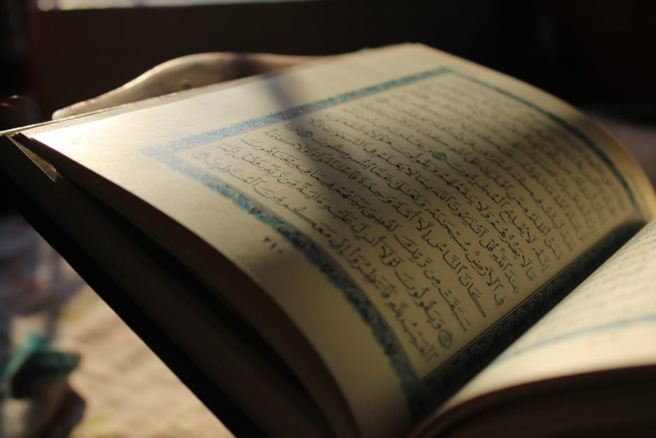 Foto mushaf Al-Quran terbuka di atas rehal kayu di dalam perpustakaan klasik dengan cahaya matahari yang masuk melalui jendela masjid, menciptakan suasana hening dan penuh ilmu.