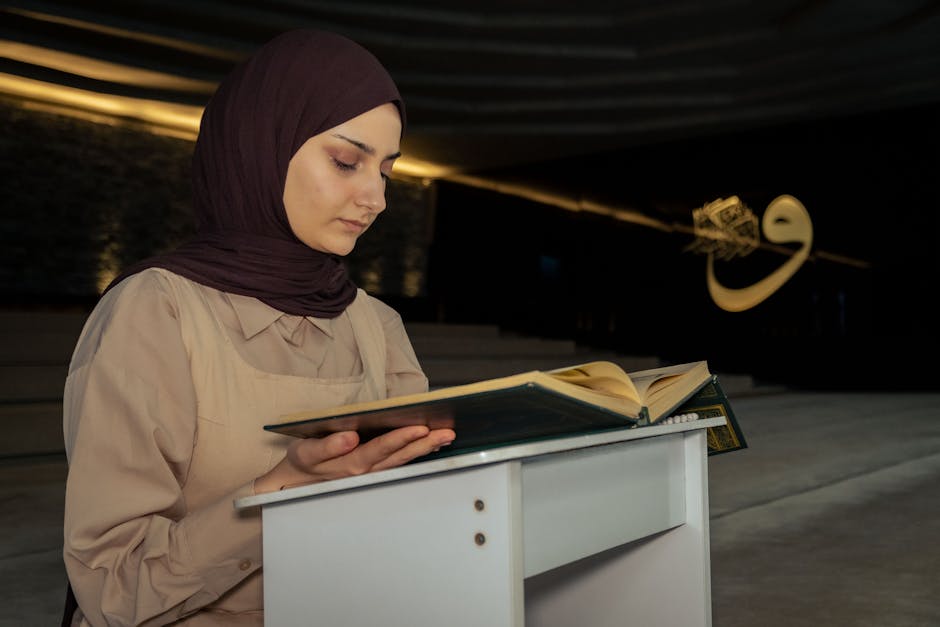 Deskripsi gambar dalam Bahasa Indonesia: Foto sebuah naskah kitab kuning klasik yang terbuka di atas meja kayu di dalam perpustakaan masjid yang tenang, dengan cahaya matahari pagi masuk melalui jendela memberikan kesan spiritual dan ilmiah yang mendalam.