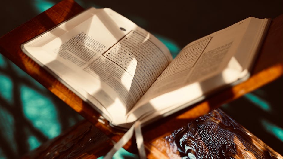 Foto sebuah naskah kuno kitab hadits dengan tulisan kaligrafi Arab yang indah di atas meja kayu perpustakaan klasik yang diterangi cahaya temaram, menciptakan suasana keilmuan yang mendalam dan tenang.