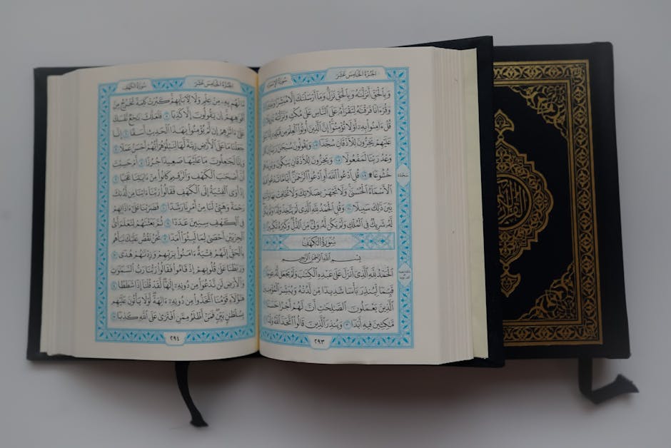 Foto sebuah mushaf Al-Quran terbuka dengan pencahayaan lembut di dalam sebuah perpustakaan klasik Islam yang dipenuhi rak buku kayu tua, menciptakan suasana ilmiah dan spiritual yang tenang.